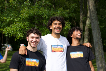 3 men wearing keep moving tees with one wearing white and others wearing black, laughing together. 